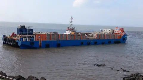 Somerset Council A blue barge full of rocks