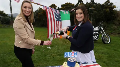 Brian Lawless/PA Wire Ciara McKevitt and her sister Andrea celebrate the beginning of the Biden presidency on the Cooley Peninsula in County Louth