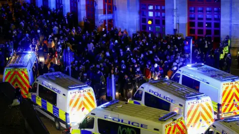 Reuters Lines of police vans and protesters in Bristol