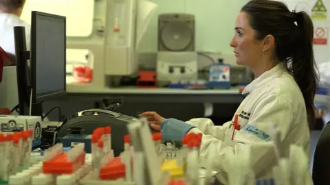 BBC Laboratory worker conducts tests