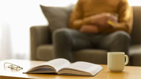 Getty Images/byryo A man sitting at a table