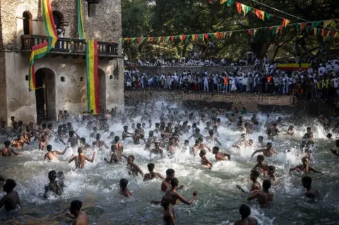 MICHELE SPATARI/AFP Ethiopian Orthodox worshippers bathe during the celebration of Timkat, the Ethiopian Orthodox Epiphany, in Gondar.