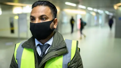 Getty Images Man waring face covering in high visibility uniform