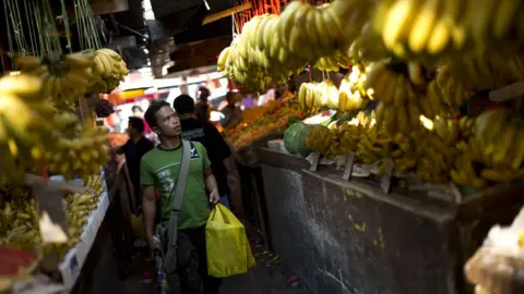Getty Images Man looking at fruit in a market