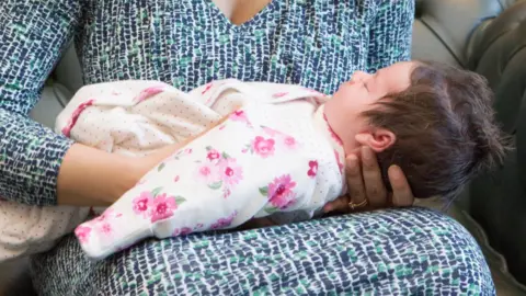 Getty Images Mother holding baby at Register Office