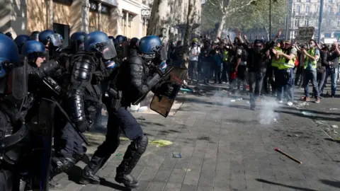 AFP Riot policemen charge during clashes with Gilets Jaunes protesters in Paris, 2019