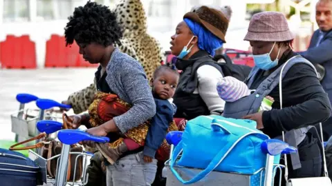 AFP Migrants arrive at Tunis-Carthage International airport on March 7, 2023 as they prepare to leave Tunis on a repatriation flight