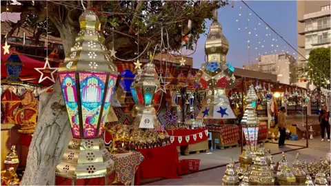 Getty Images Multi-coloured lanterns in Libya that are illuminated and hanging up.