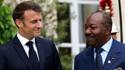 Getty Images French President Emmanuel Macron (L) greets Gabon's President Ali Bongo Odimba at the Élysée Palace in Paris, 22 June 2023