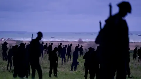 PA Media silhouettes of servicemen overlooking beach