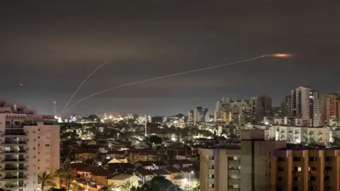 Reuters A trail of smoke is seen as rockets from Gaza are intercepted in the early morning, as seen from Ashkelon, Israel (23 February 2023)