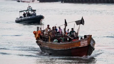 Getty Images A wooden boat carrying Rohingya refugees including many children being detained by the authorities off the coast of Malaysia