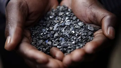 Getty Images Mineral ore being held in two hands