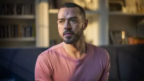 BBC Busted musician Matt Willis, wearing a pink t-shirt and looking into the distance