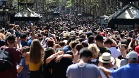 AFP Crowds of people fill Las Ramblas to observe a minutes silence.