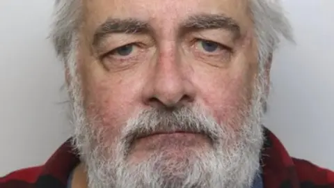 HMRC Joseph Logue, pictured with grey hair and beard