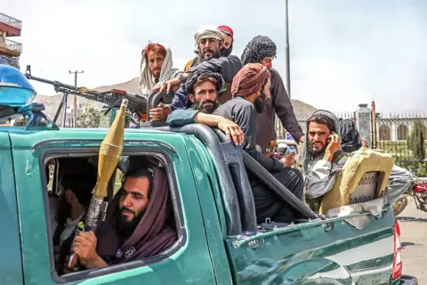 EPA Taliban fighters are seen on the back of a vehicle in Kabul, Afghanistan, on 16 August