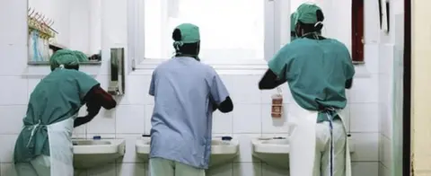 MAURO FERMARIELLO/SCIENCE PHOTO LIBRARY scrubbing up for surgery