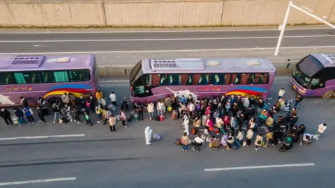 Getty Images Foxconn employees take shuttle buses to head home in Zhengzhou in the Henan province of China.