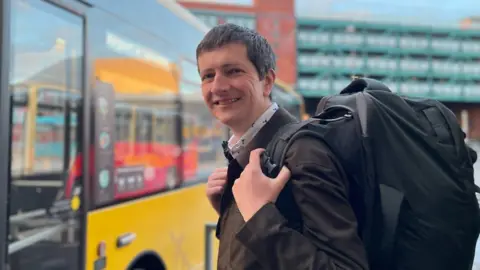 BBC Andrew Cowell boarding a bus in Derby