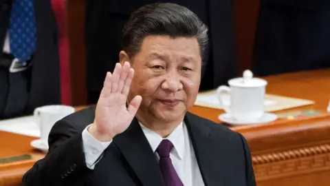 Getty Images China's President Xi Jinping waves to delegates as he is elected to a second five-year term