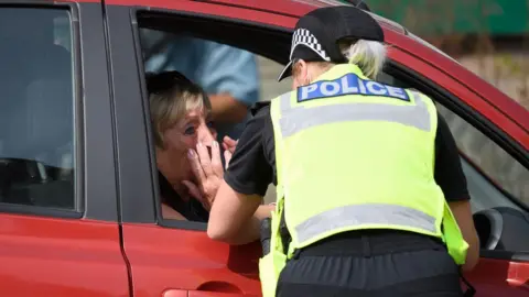 Getty Images Tearful resident with police