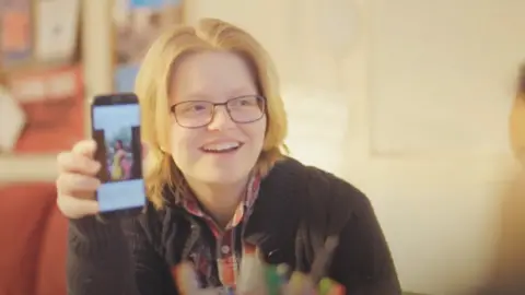 OTR Young woman holding phone up showing photo on social media