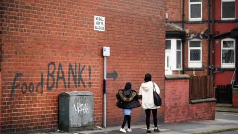 Getty Images A sign painted on the side of a house directs people to a local food bank in Leeds