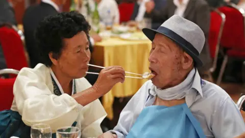 EPA South Korea"s Ahn Jong-ho (R), 100, receives food from his 70-year-old daughter Ahn Jung-soon