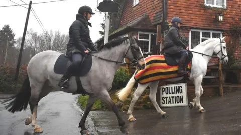 AFP Horse riders arrive at a polling station in Chiddinstone Hoath