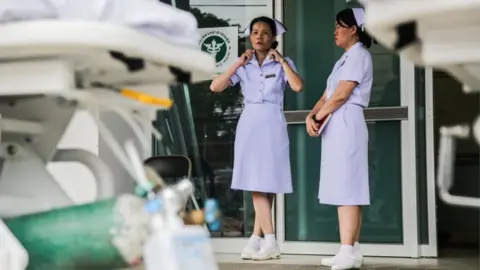 Getty Images Nurses pictured outside of Chiangrai Prachanukroh Hospital,