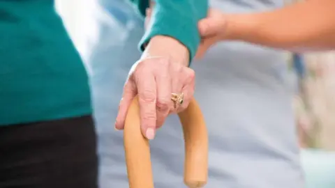 Getty Images Elderly person being guided