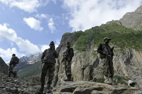 AFP Indian Border Security Force (BSF) soldiers stand guard as Hindu pilgrims begin their annual journey from Baltal Base Camp to the holy Amarnath Cave Shrine, in Baltal