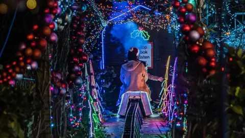 Jenny Boe Photography Person riding miniature train under Christmas lights