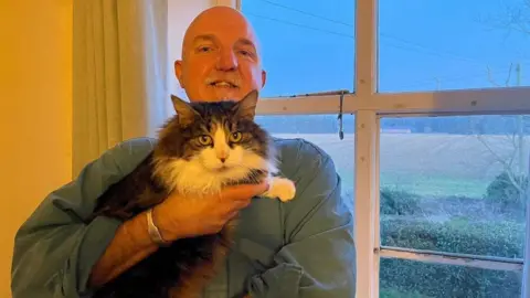 Martha Harrison/BBC Eric Wareham with his cat