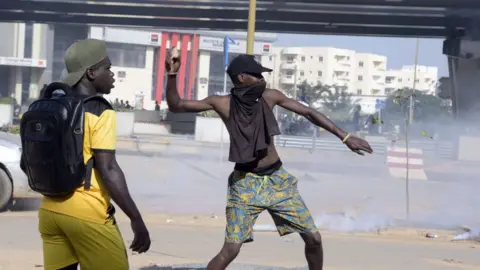 AFP A protestor throws a rock during a demonstration of members of the Guinean opposition,