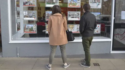 Getty Images Young people looking in an estate agents' window