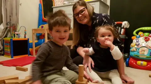 Sarah playing with her children Noah and Evie at home