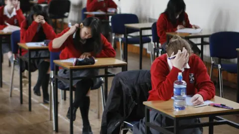 PA Media School pupils in uniform sitting an exam