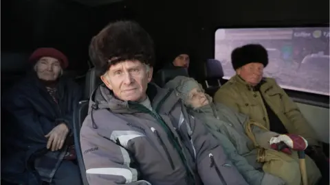 People from Avdiivka leave in a van for safety