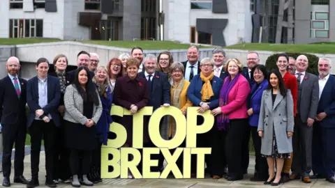 PA Media Scottish National Party candidates, including SNP Westminster leader Ian Blackford (centre) and Party leader Nicola Sturgeon (centre left), with a stop Brexit message at the party's General Election campaign launch in Edinburgh.