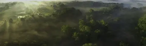 Getty Images Aerial view of foggy valley at sunrise