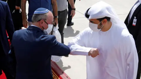 Reuters Israeli National Security Adviser Meir Ben-Shabbat elbow bumps with an Emirati official at Abu Dhabi airport in the United Arab Emirates (1 September 2020)