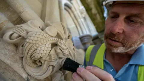 PA Media A clerk inspecting cathedral stone