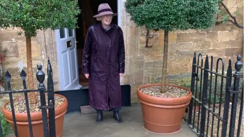 Judy Speirs A woman in a raincoat blocking flood water