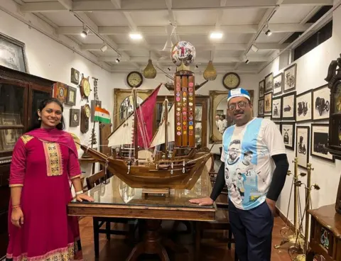  Hashir Ali / Gudam Art Gallery Hashir Ali and artist Meghna Unnikrishnan with miniature dhow he’s carrying with him to Doha