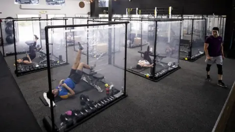 EPA Peet (R) trains his students surrounded by plastic sheets to ensure social distancing at the Inspire South Bay Fitness gym amid the coronavirus pandemic in Redondo Beach, California