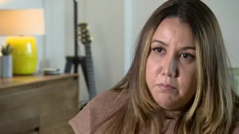 BBC Juliana Terlizzi, a woman with dark hair wearing a light brown top