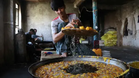 EPA A vendor prepares sweets in Herat, Afghanistan