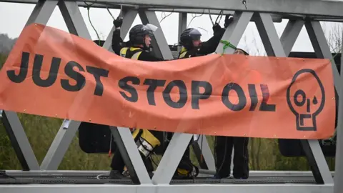 Rex Features Police officers on a motorway gantry with a Just Stop Oil sign in front of them